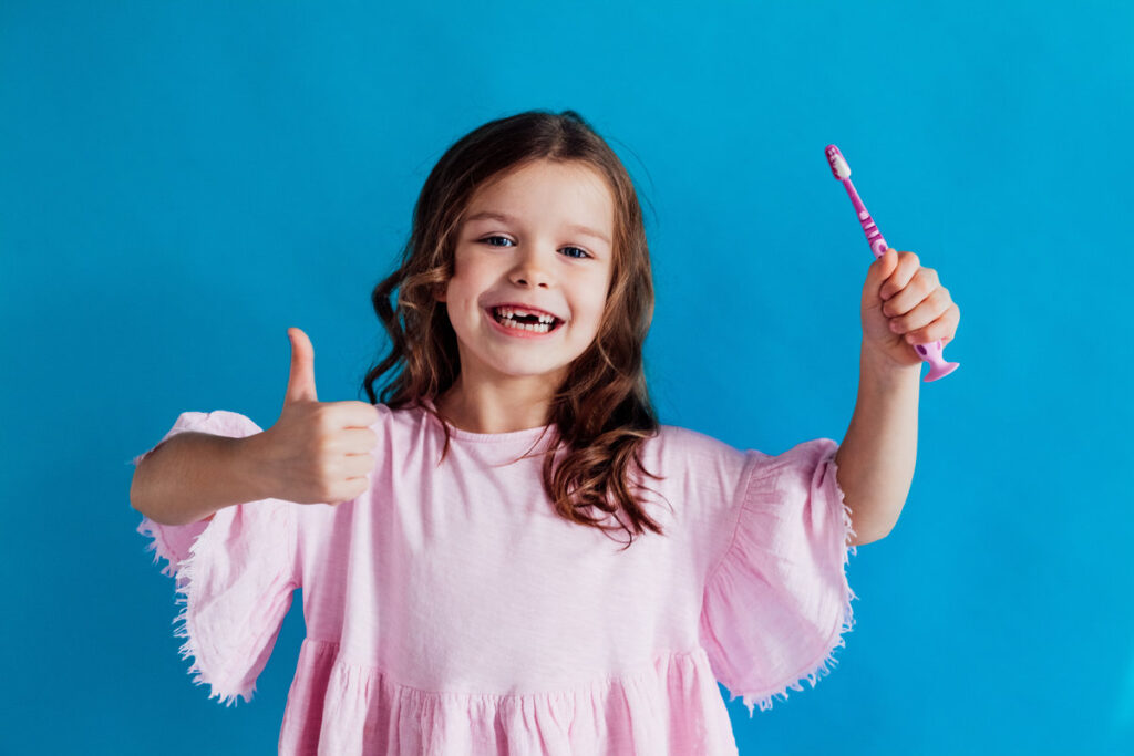 little girl with a toothbrush in dentistry