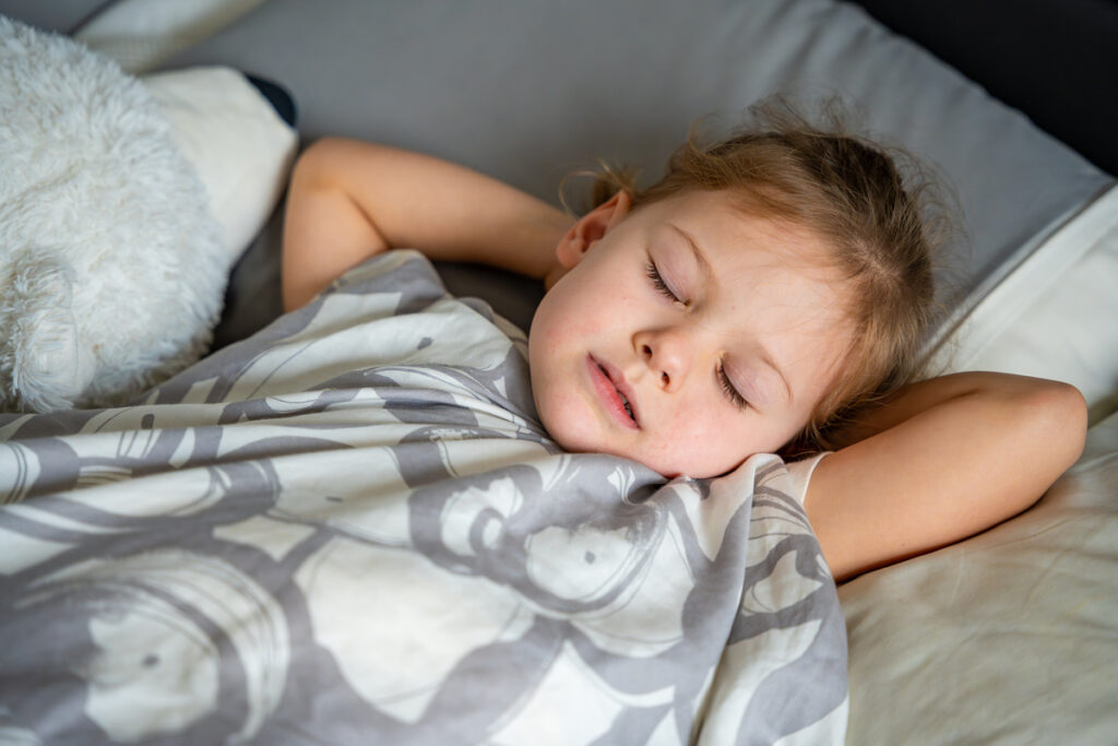 Cute little girl sleeping and grinding teeth in dreams, clenched teeth with tiredness and stress