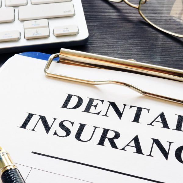 Dental insurance form and pen on a desk.