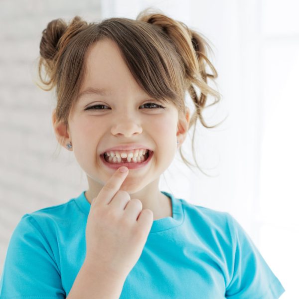 The kid lost a tooth. Baby without a tooth. Portrait of a little girl no tooth. High quality photo