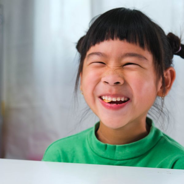 Happy cute little girl eating gelatin candy. Funny kid with chewing gum. Beautiful little girl with with vitamins for children like jelly candy.